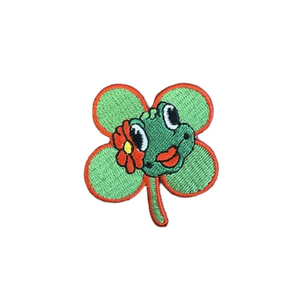 Embleem kikkerkop met klavertje